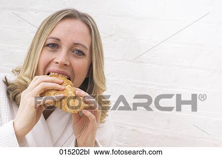 headshot of young woman biting in croissant View Large Photo Image Stock Image - headshot of young woman biting in croissant. Fotosearch