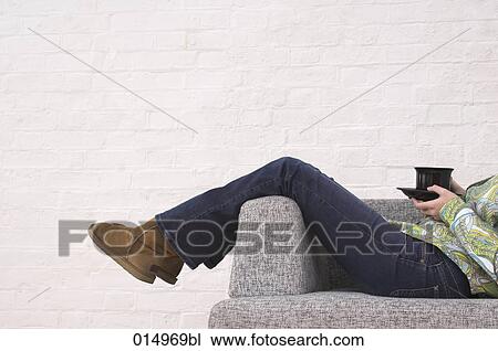 legs of woman taking a rest on armchair holding cup of tea View Large Photo Image Stock Image - legs of woman taking a rest on armchair holding cup of tea. Fotosearch