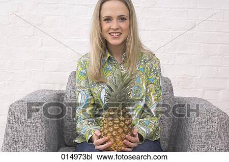portrait of blonde young woman holding pineapple View Large Photo Image Stock Image - portrait of blonde young woman holding pineapple. Fotosearch