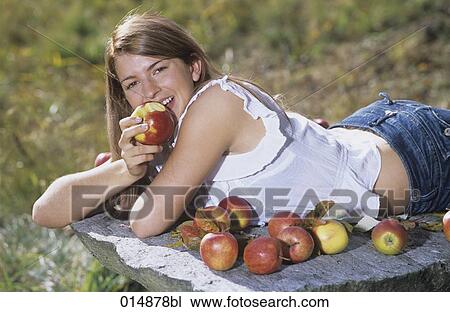 portrait of long haired young woman eating apples View Large Photo Image Stock Image - portrait of long haired young woman eating apples. Fotosearch