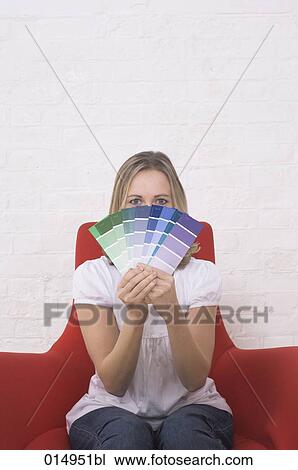 Stock Image - portrait of young woman holding colour chart. Fotosearch