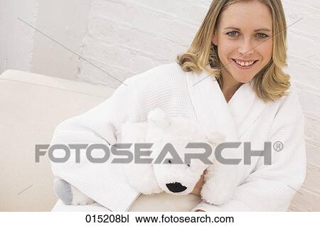 portrait of young woman in white bathrobe holding cuddly toy in shape of polar bear View Large Photo Image Stock Image - portrait of young woman in white bathrobe holding cuddly toy in shape of polar bear. Fotosearch