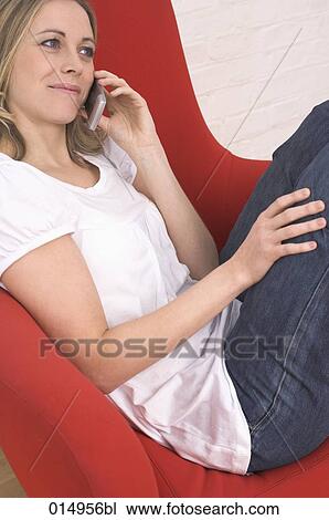 portrait of young woman relaxing on armchair and talking on mobile phone View Large Photo Image Stock Image - portrait of young woman relaxing on armchair and talking on mobile phone. Fotosearch