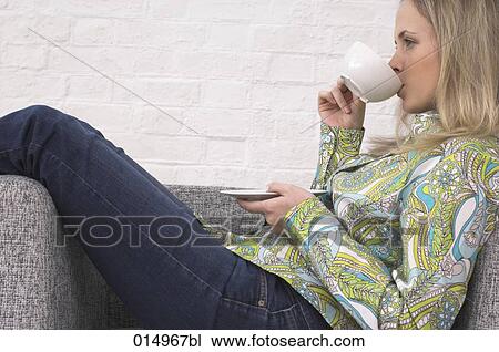 side view of young woman relaxing on armchair drinking cup of tea View Large Photo Image Stock Image - side view of young woman relaxing on armchair drinking cup of tea. Fotosearch