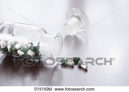 Stock Image - still life of capsules coming out of medicine bottle. Fotosearch
