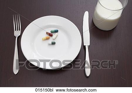 Stock Image - still life of five capsules on plate. Fotosearch