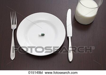 Stock Image - still life of single capsule on plate. Fotosearch