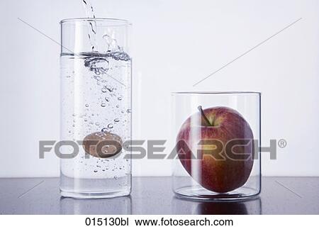still life of tablet falling in glass and red apple View Large Photo Image Stock Image - still life of tablet falling in glass and red apple. Fotosearch