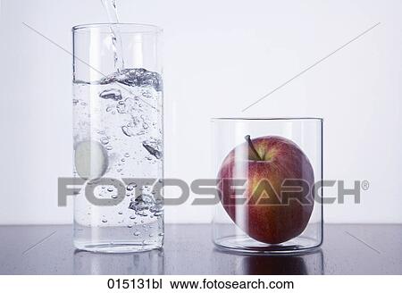 still life of tablet falling in glass and red apple View Large Photo Image Stock Image - still life of tablet falling in glass and red apple. Fotosearch