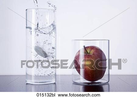 still life of tablet falling in glass and red apple View Large Photo Image Stock Image - still life of tablet falling in glass and red apple. Fotosearch