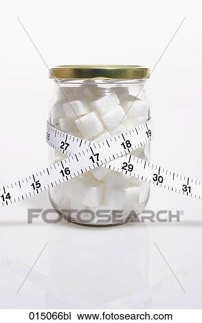 Stock Image - tape measure over glass filled with sugar cubes. Fotosearch