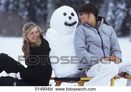 two woman sitting on sledge with snowman smiling at each other View Large Photo Image Stock Image - two woman sitting on sledge with snowman smiling at each other. Fotosearch