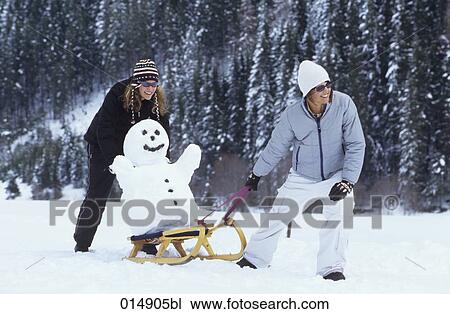 two women pulling snowman on sledge View Large Photo Image Stock Image - two women pulling snowman on sledge. Fotosearch