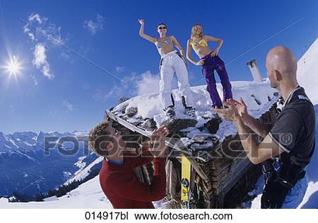 two young women in bikini tops dancing on roof of alpine hut in winter View Large Photo Image Stock Image - two young women in bikini tops dancing on roof of alpine hut in winter. Fotosearch