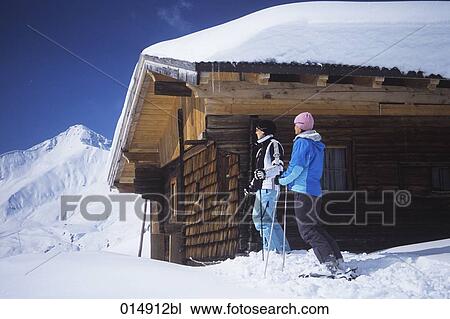 two young women on skis at alpine hut View Large Photo Image Stock Image - two young women on skis at alpine hut. Fotosearch