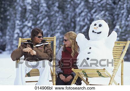 two young women sitting on deck chairs in snow together with snowman View Large Photo Image Stock Image - two young women sitting on deck chairs in snow together with snowman . Fotosearch