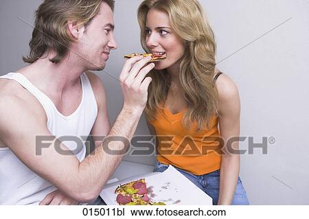 young couple at home man feeding woman piece of pizza View Large Photo Image Stock Image - young couple at home man feeding woman piece of pizza. Fotosearch