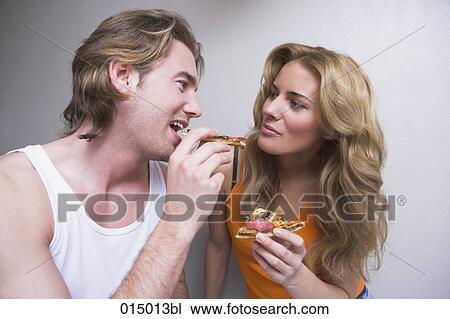 young couple eating pizza tenderly looking at each other View Large Photo Image Stock Image - young couple eating pizza tenderly looking at each other. Fotosearch