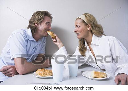 young couple having breakfast woman feeding man croissant View Large Photo Image Stock Image - young couple having breakfast woman feeding man croissant. Fotosearch
