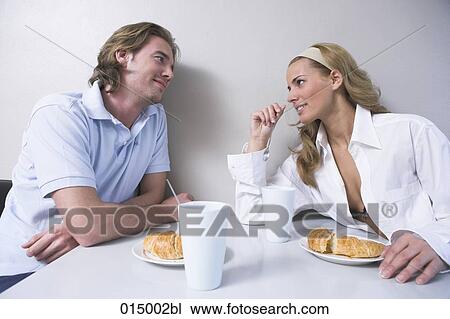 young couple sitting at breakfast table tenderly looking at each other View Large Photo Image Stock Image - young couple sitting at breakfast table tenderly looking at each other. Fotosearch