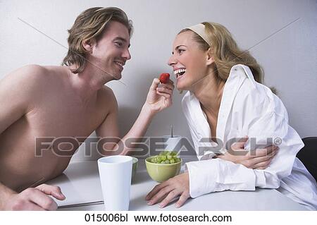 young couple sitting at table together man feeding woman strawberry View Large Photo Image Stock Image - young couple sitting at table together man feeding woman strawberry. Fotosearch