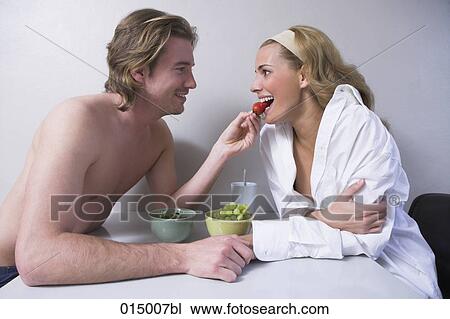 young couple sitting at table together man feeding woman strawberry View Large Photo Image Stock Image - young couple sitting at table together man feeding woman strawberry. Fotosearch