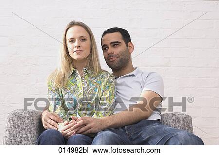 young couple sitting on armchair man tenderly embracing woman View Large Photo Image Stock Image - young couple sitting on armchair man tenderly embracing woman. Fotosearch