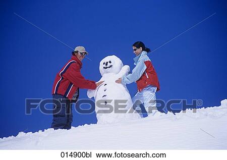 young man and young woman making snowman together View Large Photo Image Stock Image - young man and young woman making snowman together. Fotosearch