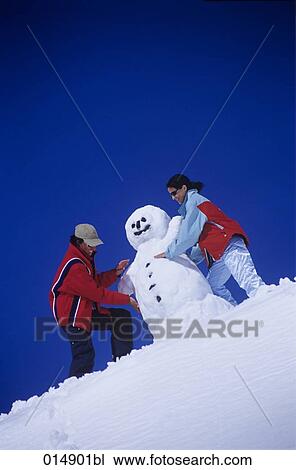 young man and young woman making snowman together View Large Photo Image Stock Image - young man and young woman making snowman together. Fotosearch