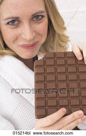 young woman biting into giant chocolate bar View Large Photo Image Stock Image - young woman biting into giant chocolate bar. Fotosearch