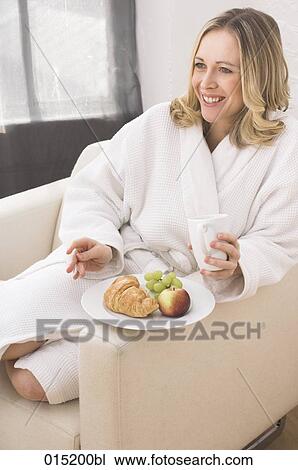 young woman in white bathrobe enjoying breakfast in arm chair View Large Photo Image Stock Image - young woman in white bathrobe enjoying breakfast in arm chair. Fotosearch