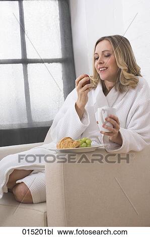 young woman in white bathrobe enjoying breakfast in arm chair View Large Photo Image Stock Image - young woman in white bathrobe enjoying breakfast in arm chair. Fotosearch