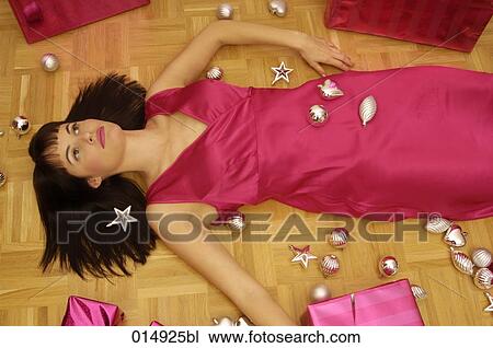 young woman lying on the floor surrounded by presents and christmas decorations View Large Photo Image Stock Image - young woman lying on the floor surrounded by presents and christmas decorations. Fotosearch