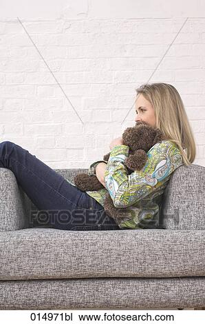 young woman sitting on armchair holding teddy bear View Large Photo Image Stock Image - young woman sitting on armchair holding teddy bear. Fotosearch