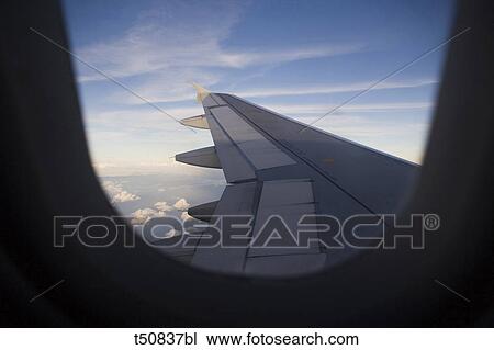 Airplane wings seen through window View Large Photo Image Stock Image - Airplane wings seen through window. Fotosearch