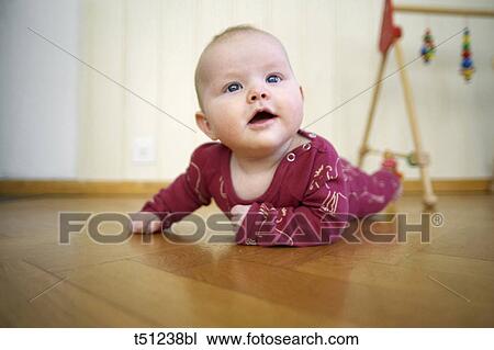 Baby lying on floor View Large Photo Image Stock Image - Baby lying on floor. Fotosearch