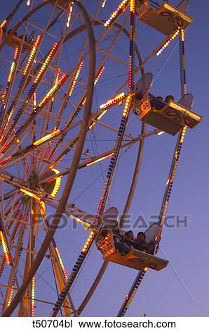 Stock Image - Big wheel spinning in the early evening. Fotosearch
