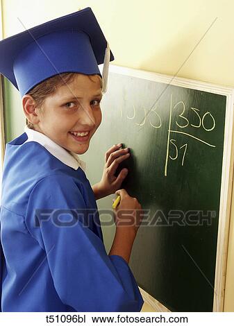 Boy in graduation clothes writing on blackboard View Large Photo Image Stock Image - Boy in graduation clothes writing on blackboard. Fotosearch