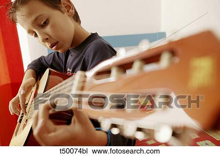Boy playing guitar View Large Photo Image Stock Image - Boy playing guitar. Fotosearch