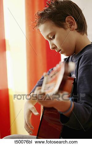 Stock Image - Boy playing guitar. Fotosearch