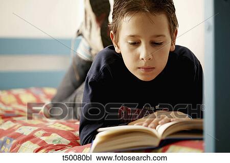 Boy reading book in bed View Large Photo Image Stock Image - Boy reading book in bed. Fotosearch