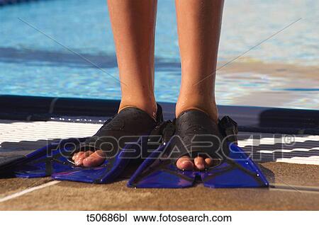 Stock Image - Boy's legs swim fins. Fotosearch