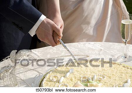 Bride and groom cutting wedding cake View Large Photo Image Stock Image - Bride and groom cutting wedding cake. Fotosearch