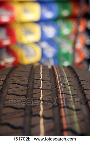 Close up of a tire tread on a brand new tire with colorful trays on a shelf in the background in a garage View Large Photo Image Stock Image - Close up of a tire tread on a brand new tire with colorful trays on a shelf in the background in a garage. Fotosearch