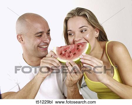 Couple eating slice of watermelon View Large Photo Image Stock Image - Couple eating slice of watermelon. Fotosearch