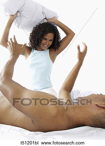 Stock Image - Couple having a pillow fight. Fotosearch