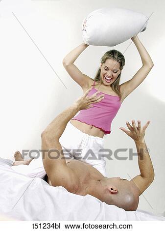 Couple having a pillow fight View Large Photo Image Stock Image - Couple having a pillow fight. Fotosearch
