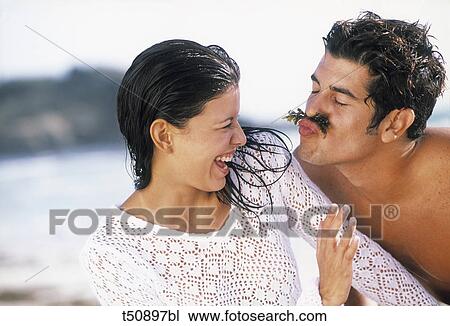 Stock Image - Couple having fun on beach. Fotosearch