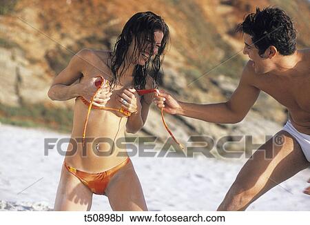 Stock Image - Couple having fun on beach. Fotosearch