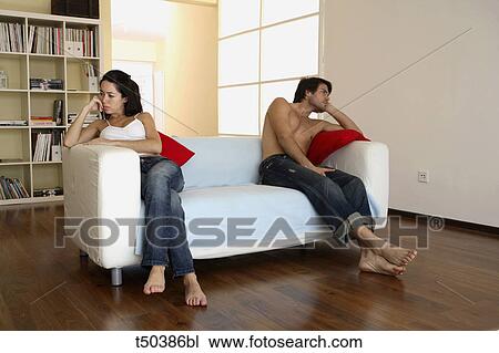 Couple in disagreement sitting on sofa View Large Photo Image Stock Image - Couple in disagreement sitting on sofa. Fotosearch